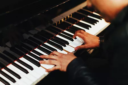 Person playing the piano by Gabriel Gurrola downloaded from Unsplash