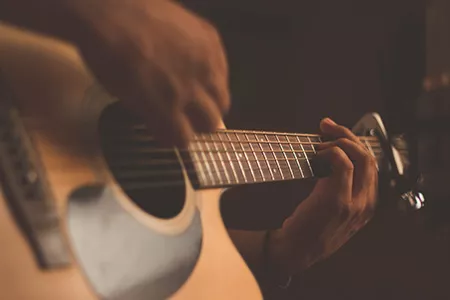 Person playing the Guitar:  Image by Jefferson Santos downloaded from UnSplash