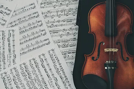 Violin and sheet music by Stafany Andrade downloaded from Unsplash